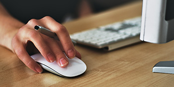Woman's hand clicking a computer mouse
